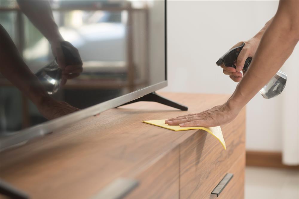 lightly spraying wood furniture to clean